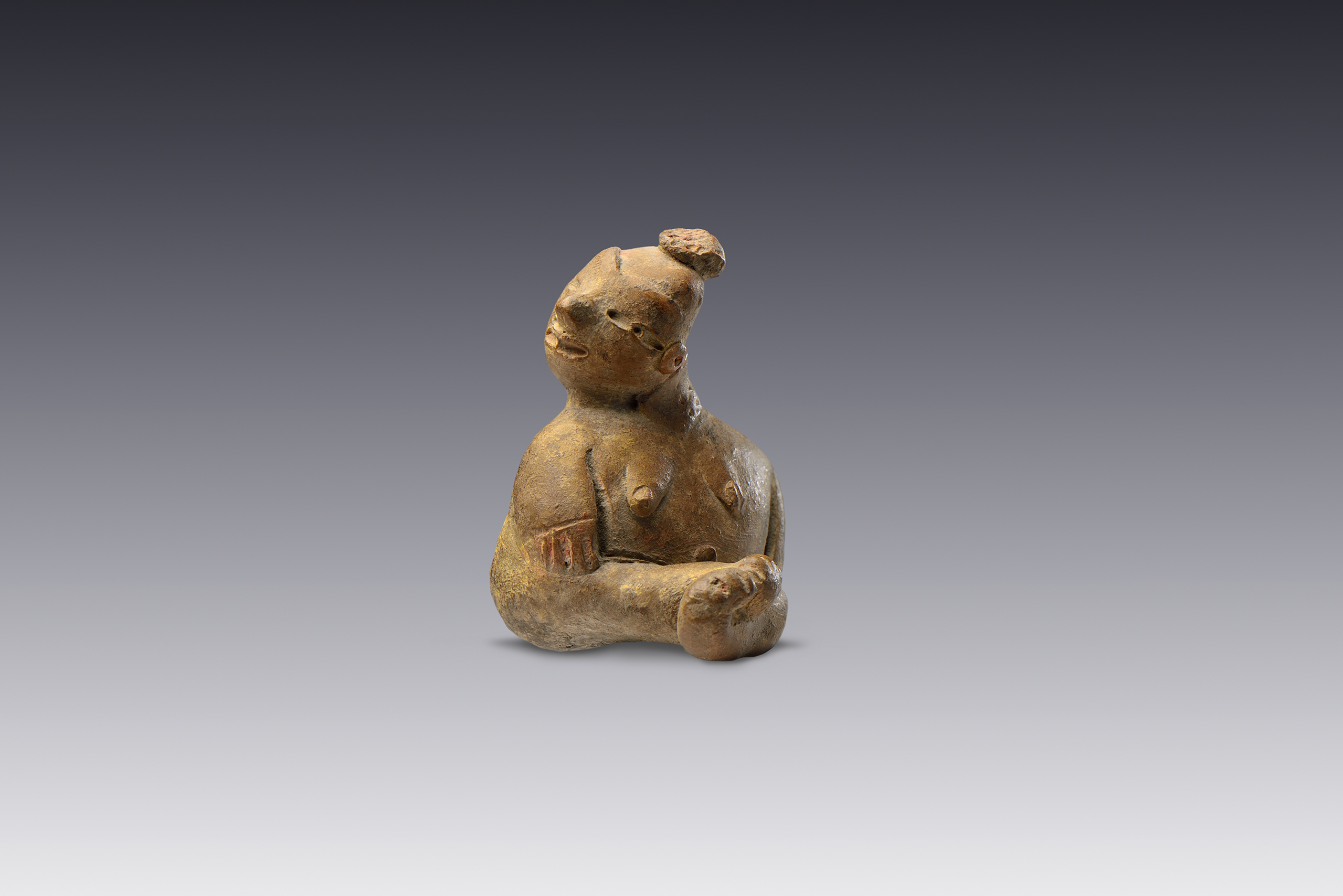 Personaje sentado con brazos pegados al cuerpo y piernas entrecruzadas.  | El México antiguo. Salas de Arte Prehispánico | Museo Amparo, Puebla