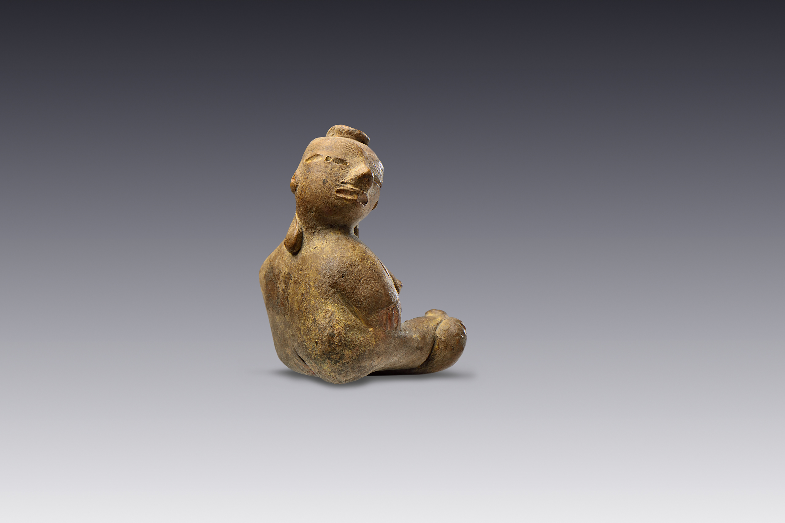Personaje sentado con brazos pegados al cuerpo y piernas entrecruzadas.  | El México antiguo. Salas de Arte Prehispánico | Museo Amparo, Puebla