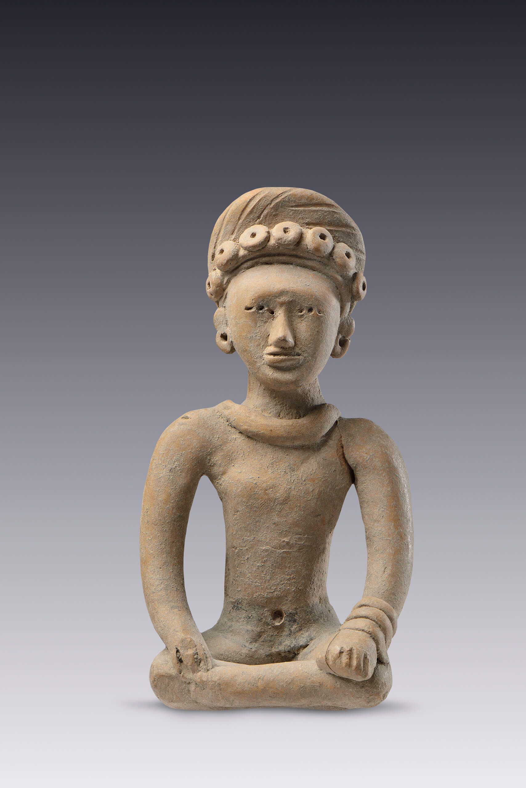Figurilla sentada con sus brazos extendidos y sus manos sobre las rodillas | El México antiguo. Salas de Arte Prehispánico | Museo Amparo, Puebla
