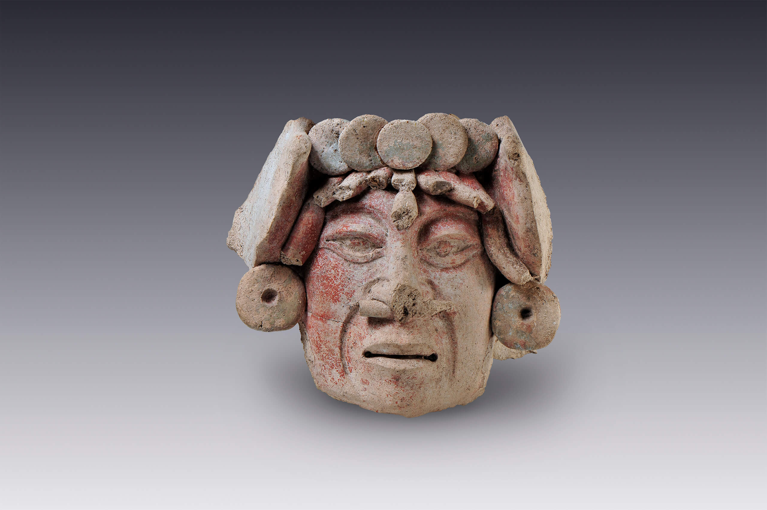 Rostro con orejeras y pintura facial (fragmento) | El México antiguo. Salas de Arte Prehispánico | Museo Amparo, Puebla