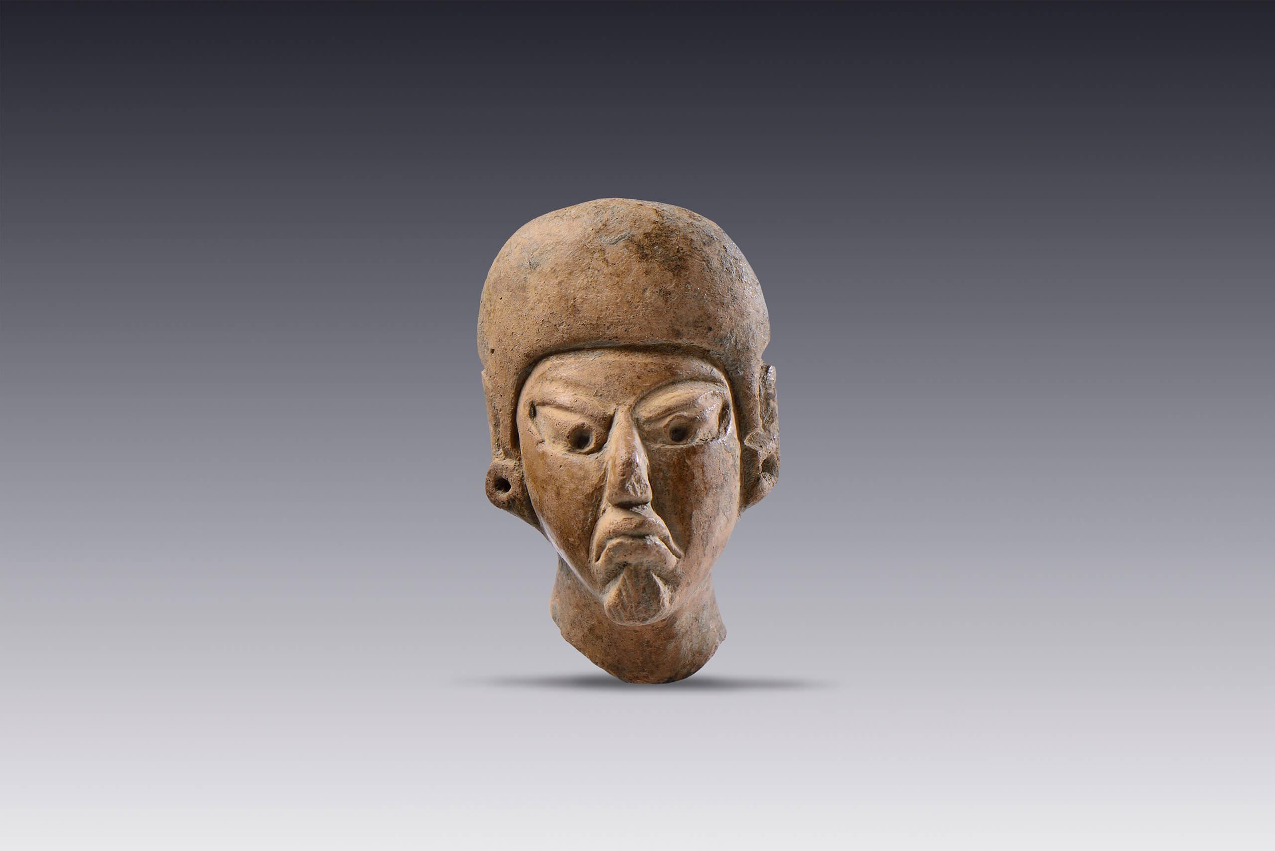 Cabeza masculina con tocado tipo casco y orejeras  | El M&eacute;xico antiguo. Salas de Arte Prehisp&aacute;nico | Museo Amparo, Puebla