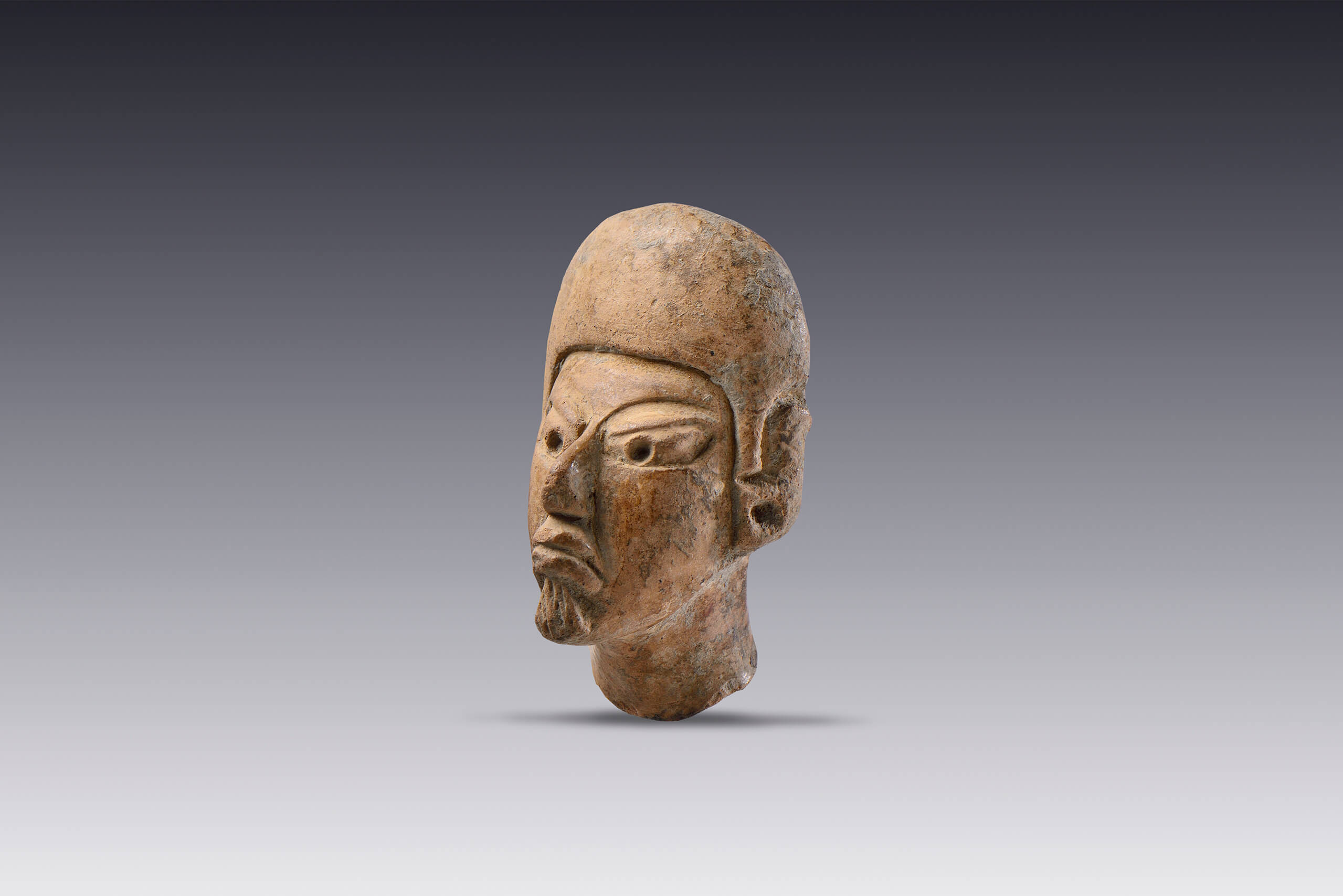 Cabeza masculina con tocado tipo casco y orejeras  | El M&eacute;xico antiguo. Salas de Arte Prehisp&aacute;nico | Museo Amparo, Puebla