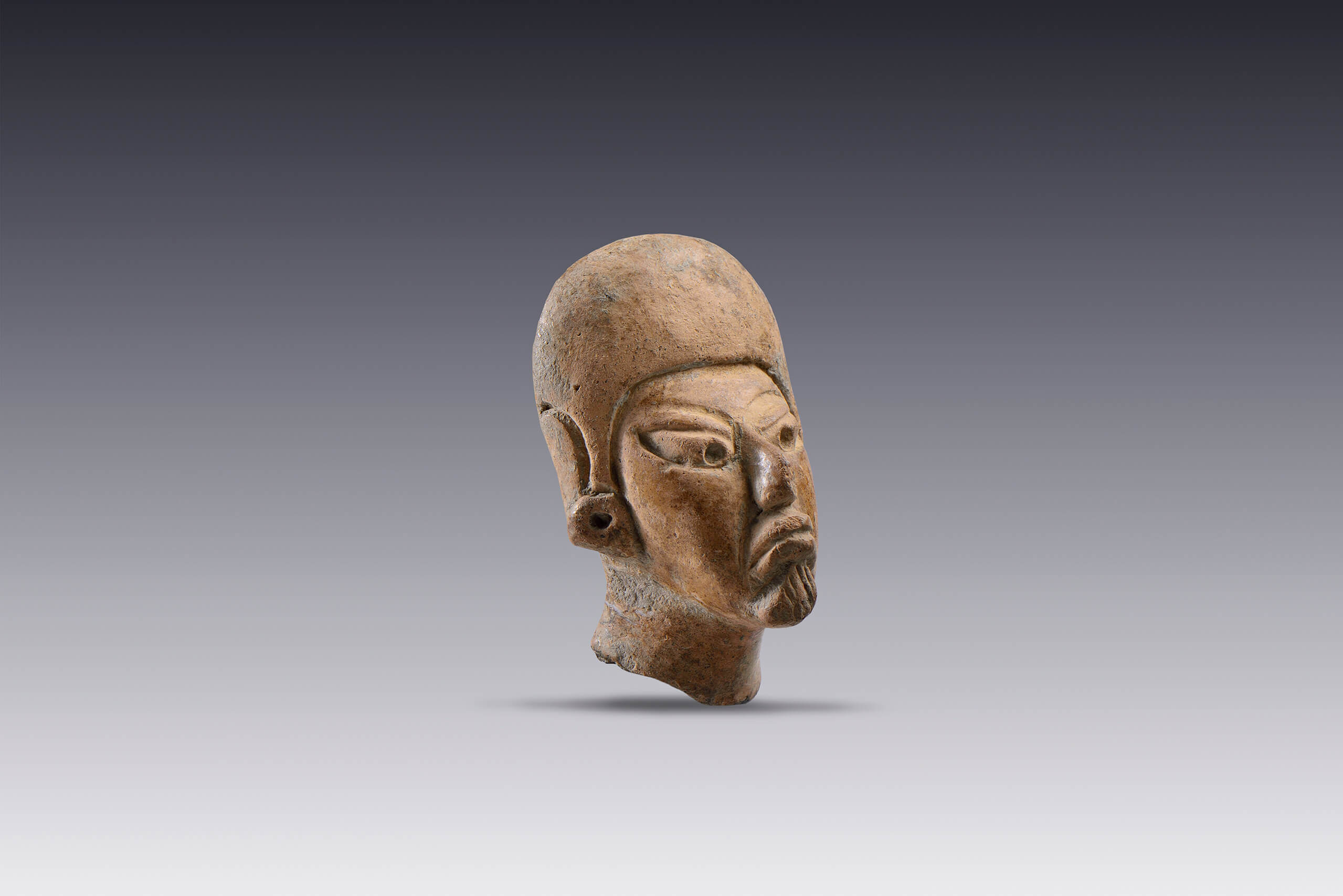 Cabeza masculina con tocado tipo casco y orejeras  | El M&eacute;xico antiguo. Salas de Arte Prehisp&aacute;nico | Museo Amparo, Puebla