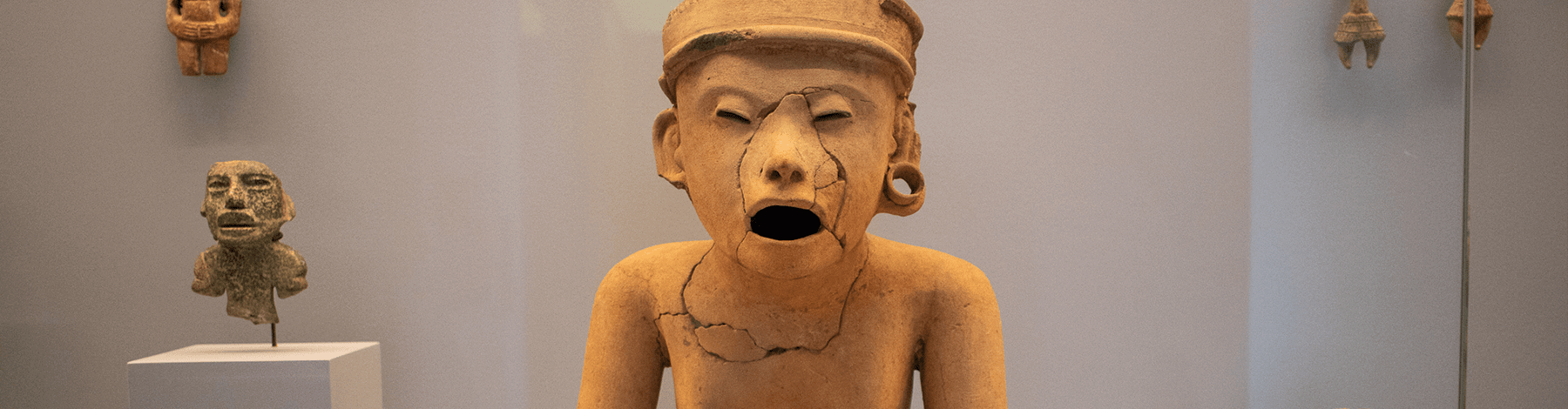 Escultura de hombre sentado que parece entonar un canto | Museo Amparo, Puebla | Museo Amparo, Puebla.